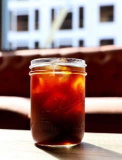 Cold brew coffee in a mason jar glass at a coffee shop