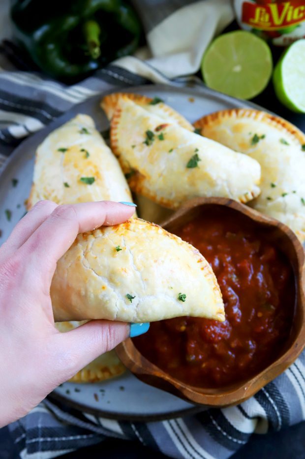 Dipping a chicken empanada into salsa