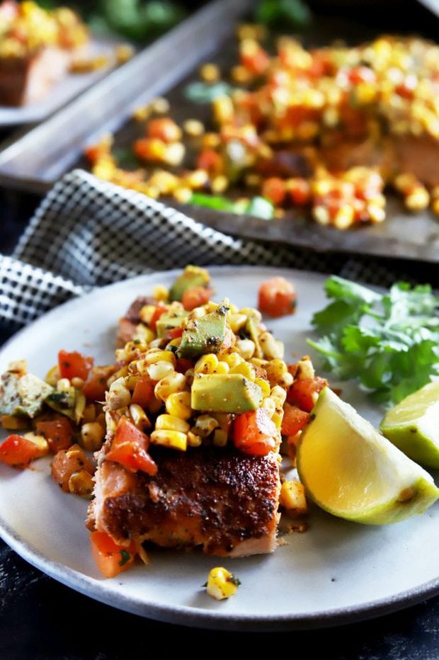 Individual salmon filet on a plate with lime and salsa