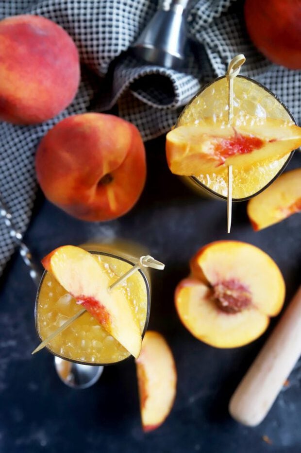 Overhead shot of highball cocktails with fresh peaches