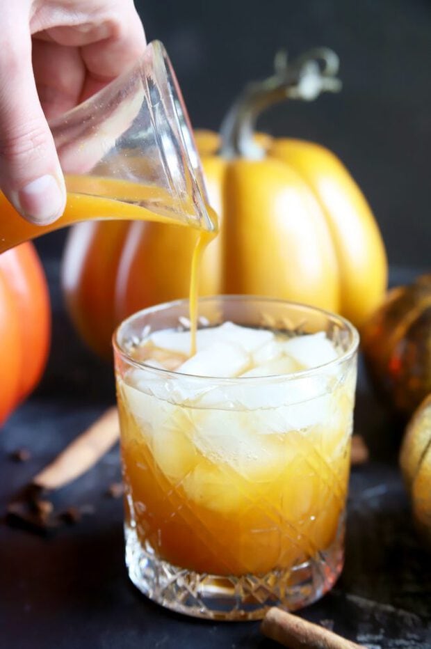 Pouring simple syrup into a pumpkin cocktail