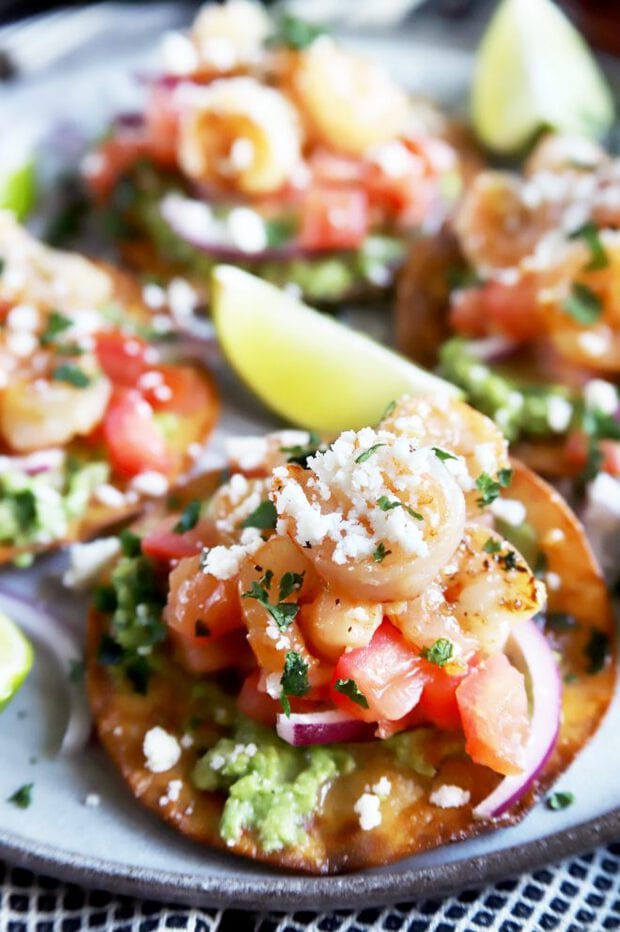 Close up of a shrimp tostada with limes