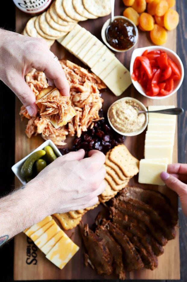 Hands in for BBQ meat, cheese, and crackers