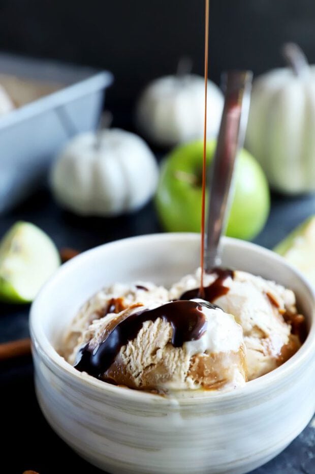 Pouring over chocolate sauce on ice cream in a bowl