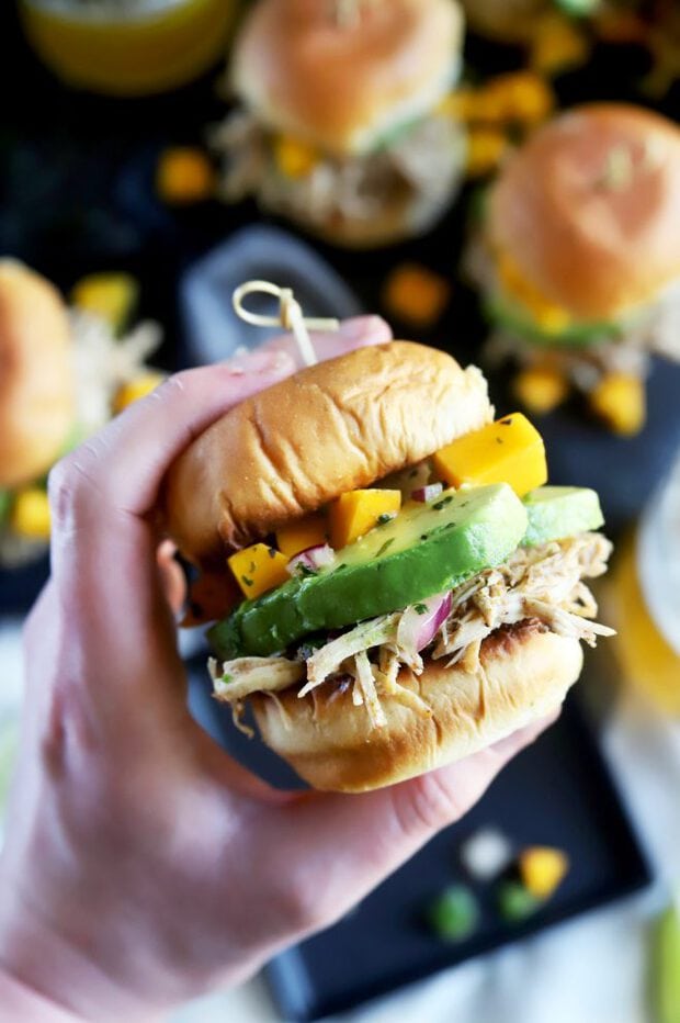 Hand holding a jerk chicken slider