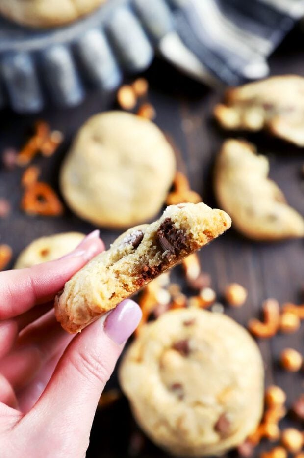 Holding a chocolate chip cookie with a bite taken out of it