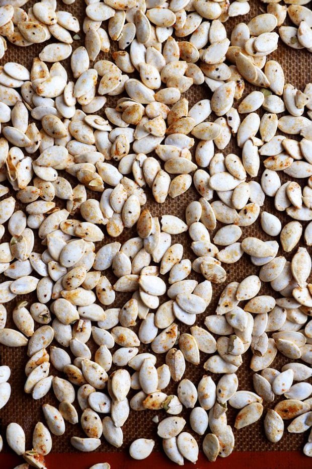 Overhead photo of pumpkin seeds on a baking sheet