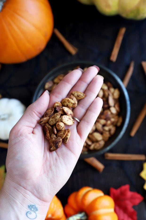 Hand holding a handful of roasted pumpkin seeds