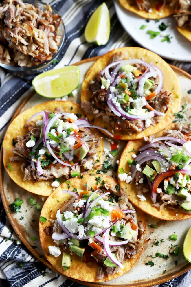 Crispy pork carnitas tostadas on a platter