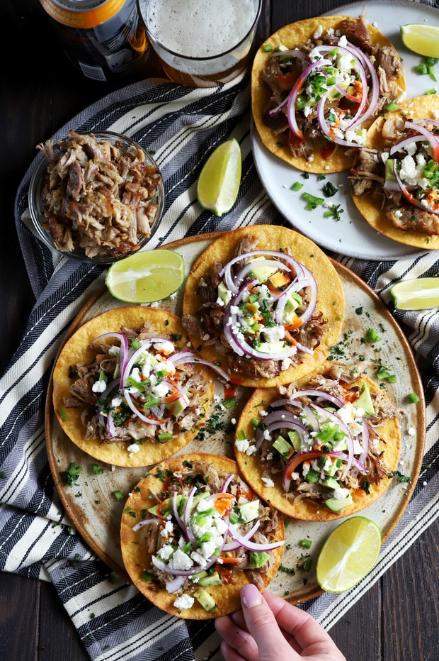 Hand grabbing a tostada from a platter