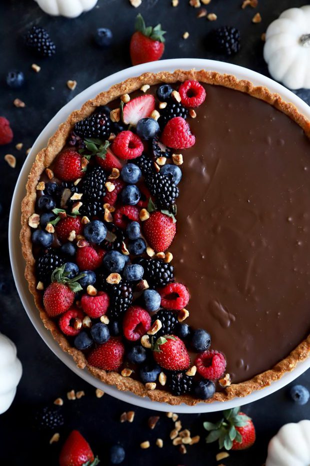 Ganache tart topped with fresh berries overhead photo