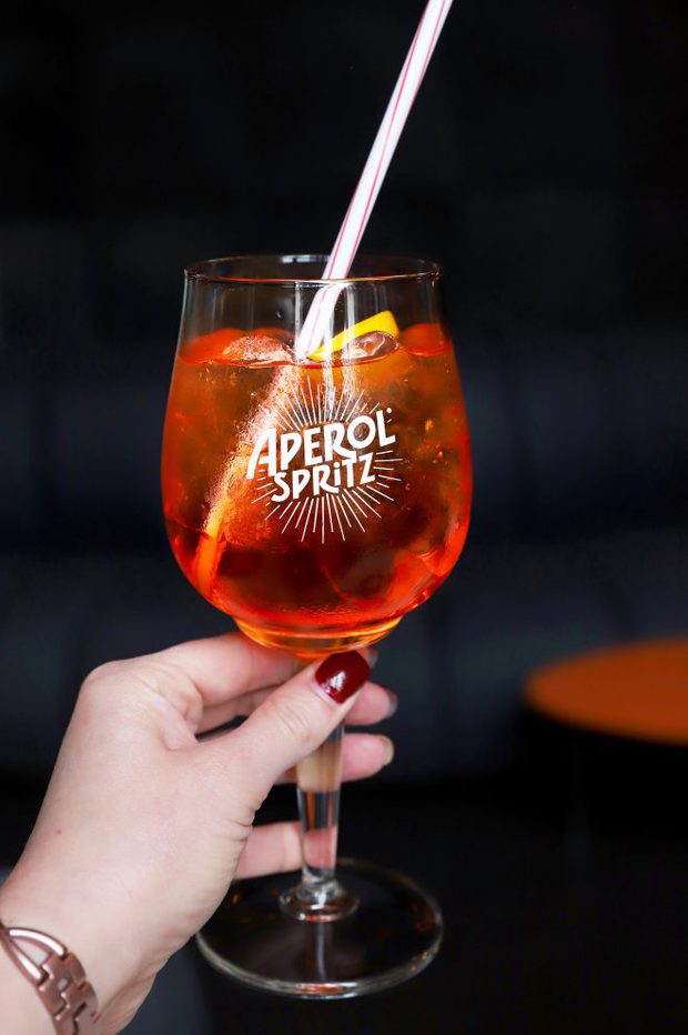 Hand holding an Aperol Spritz for a guide to Milan