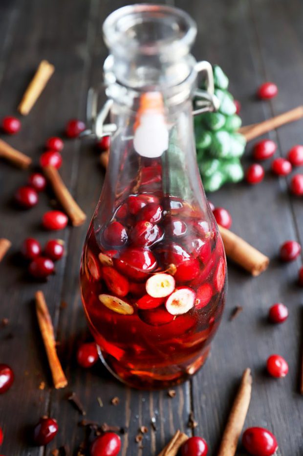 Whiskey in a bottle with cranberries and cinnamon