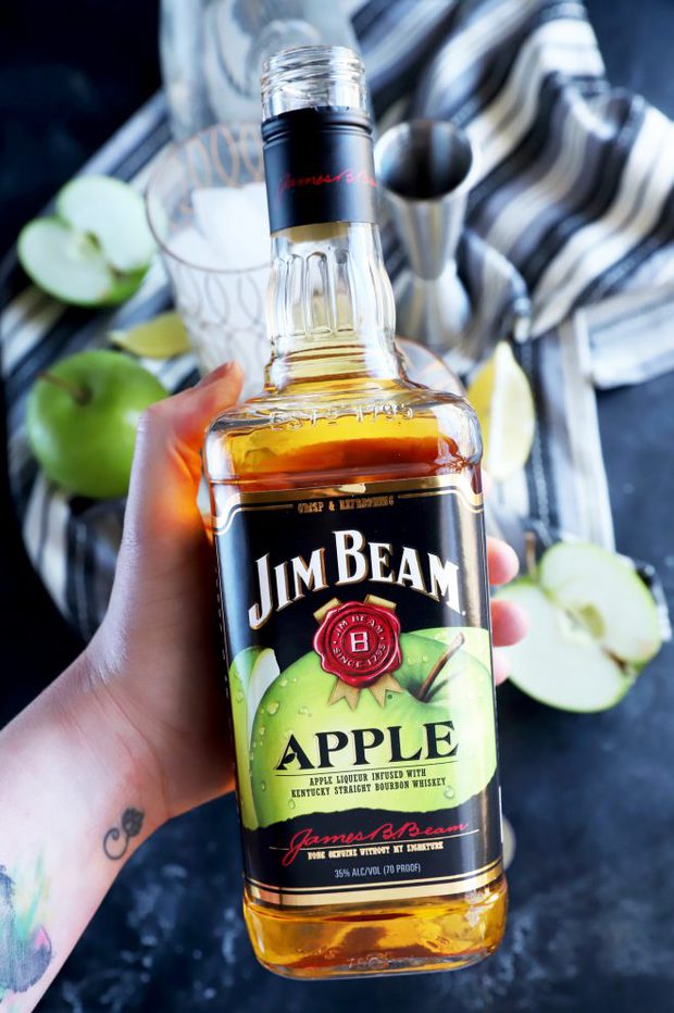 Photo of hand holding Jim Bean Apple bottle