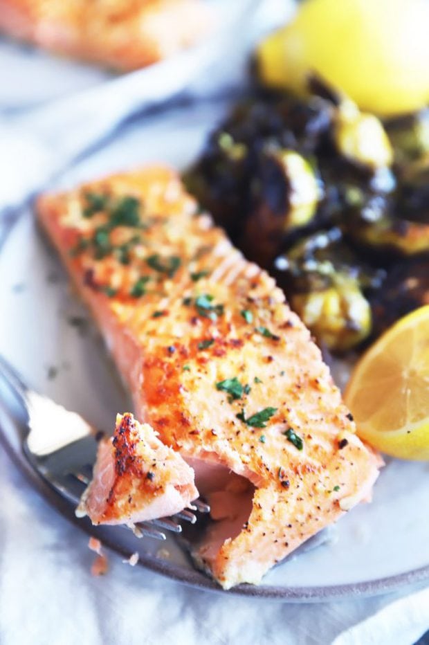 Fork taking a bite of baked salmon