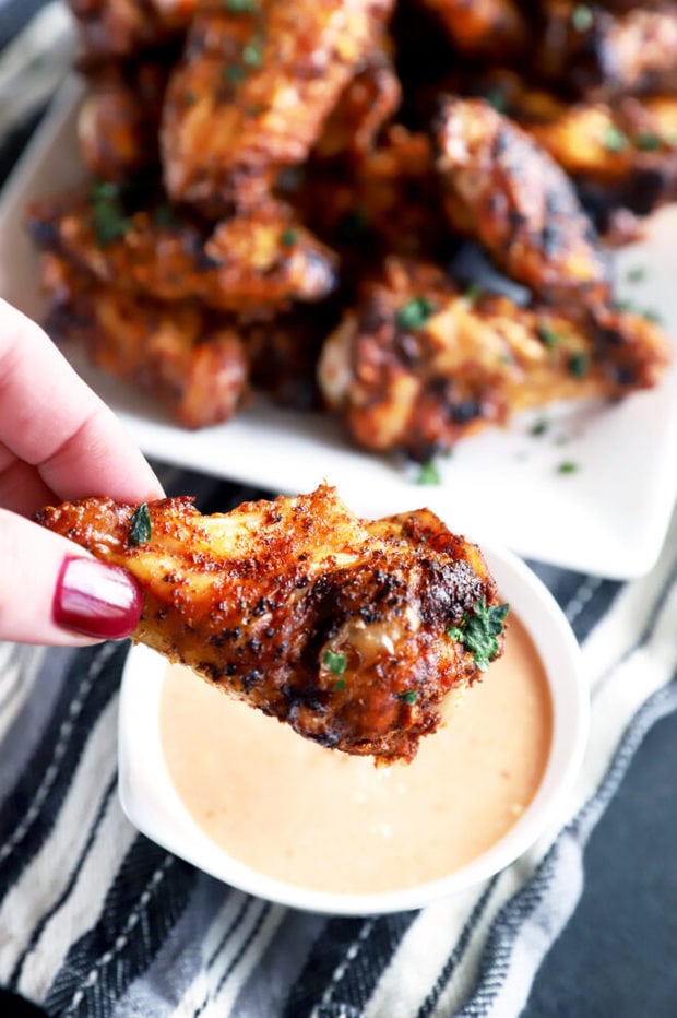 Dipping a dry rub wing in sauce photo