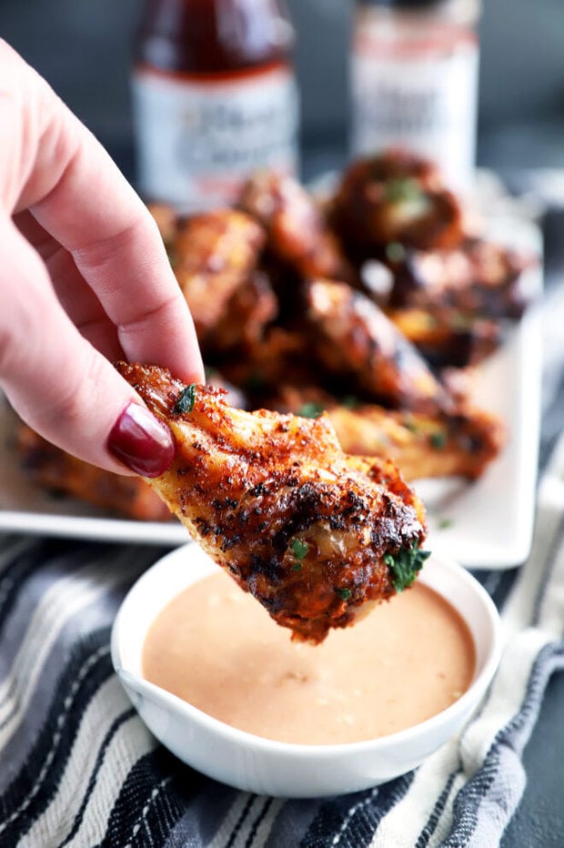 Dipping photo of a chicken wing in sauce