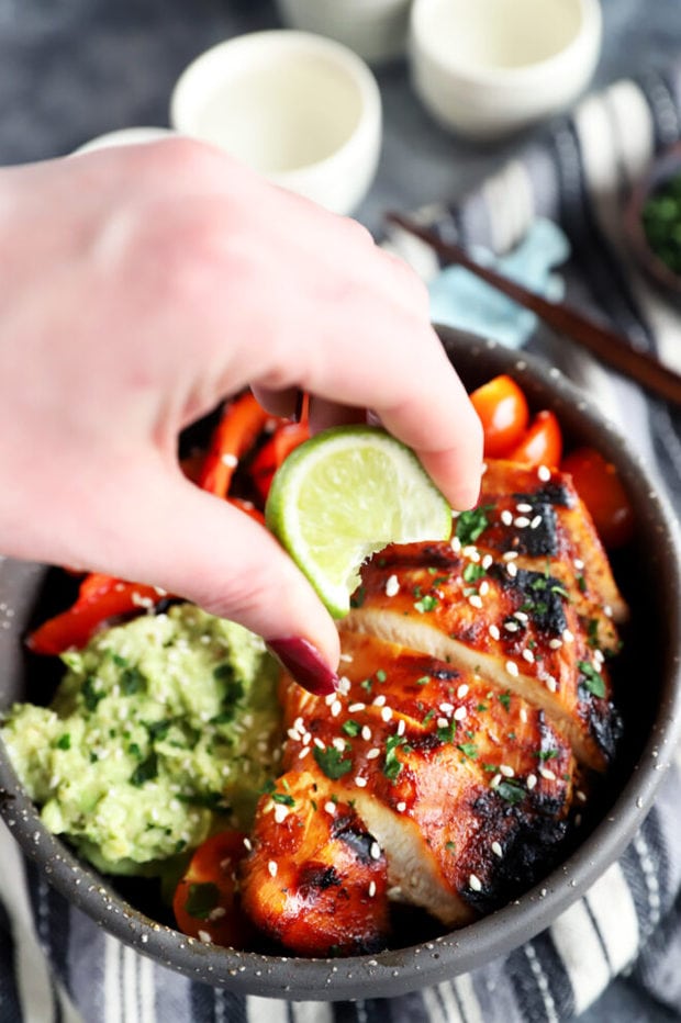 Picture of hand squeezing lime over rice bowl