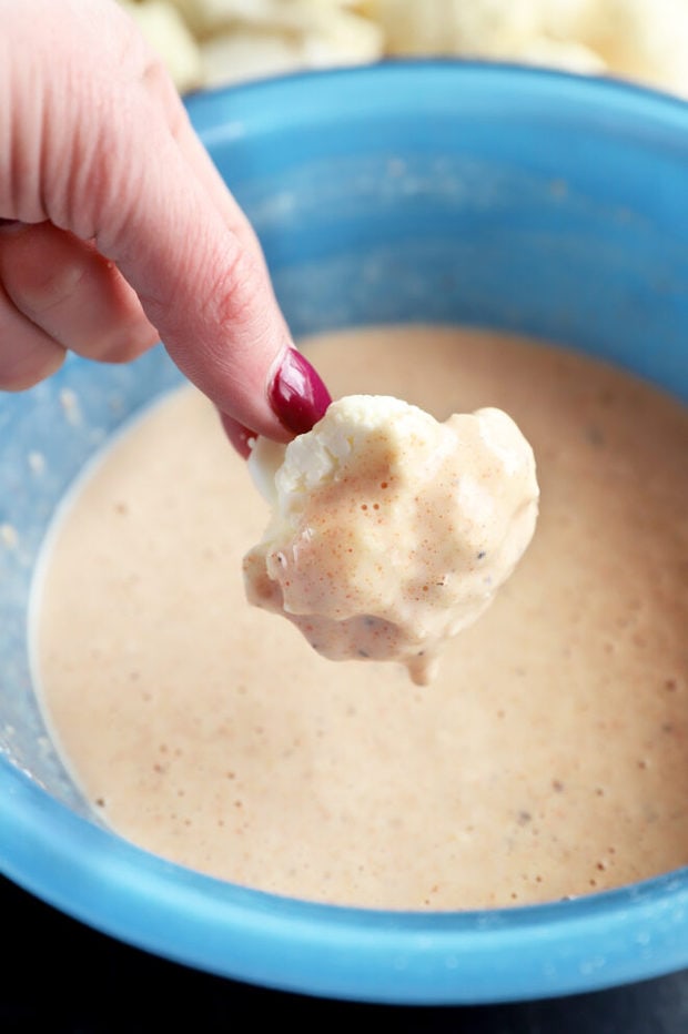 Cauliflower being dipped in batter photo