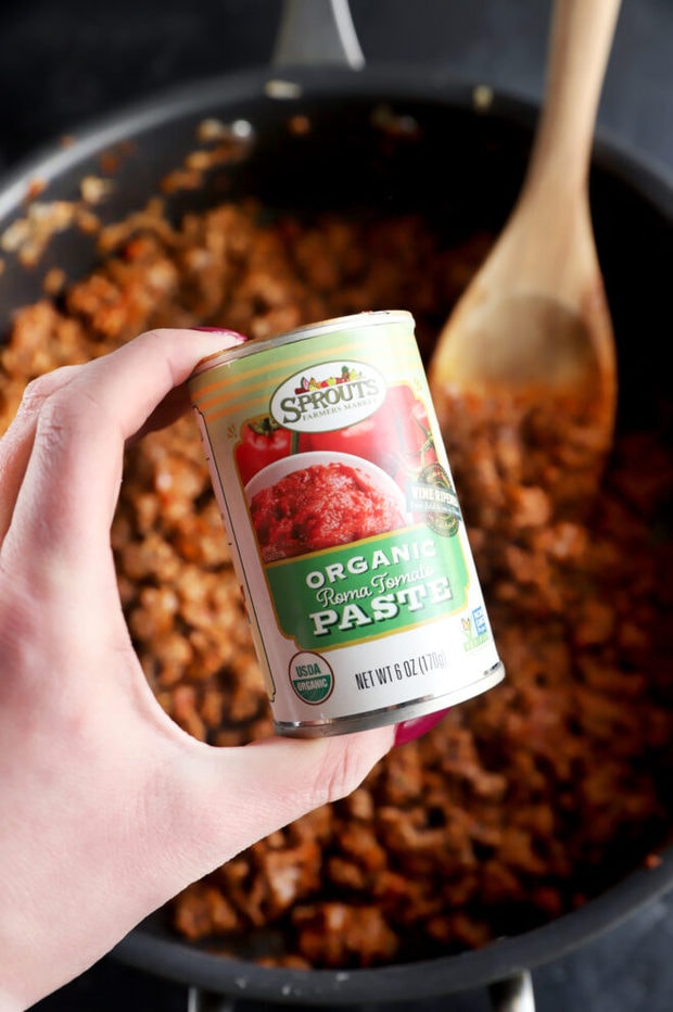 Photo of hand holding can of tomato paste