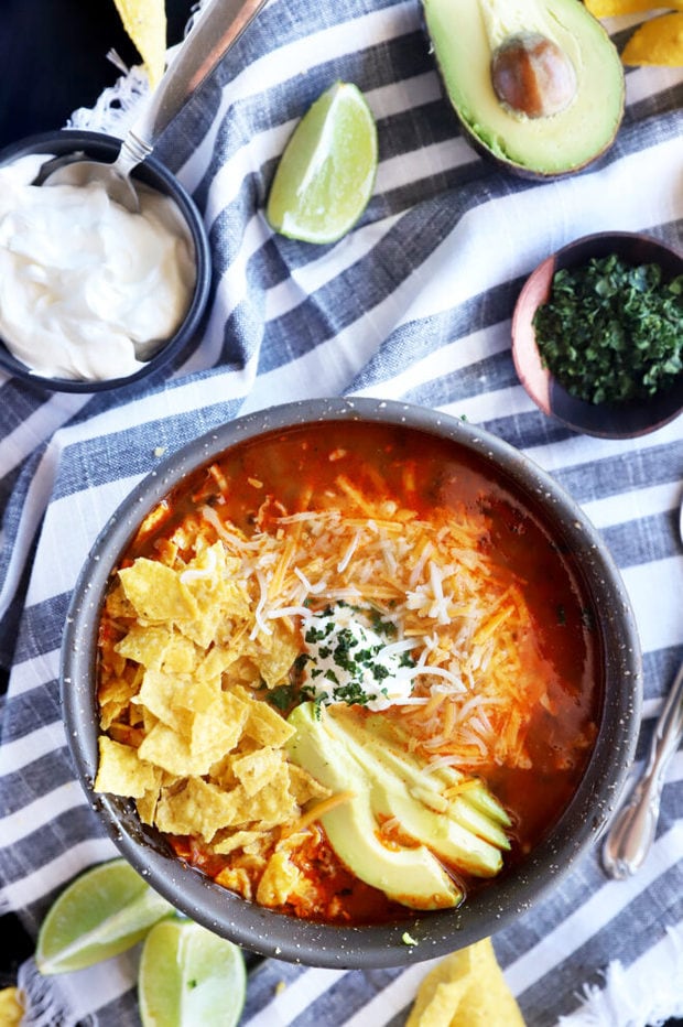 Tortilla soup with toppings on a table photo