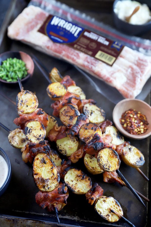 Side view of loaded bacon potato skewers