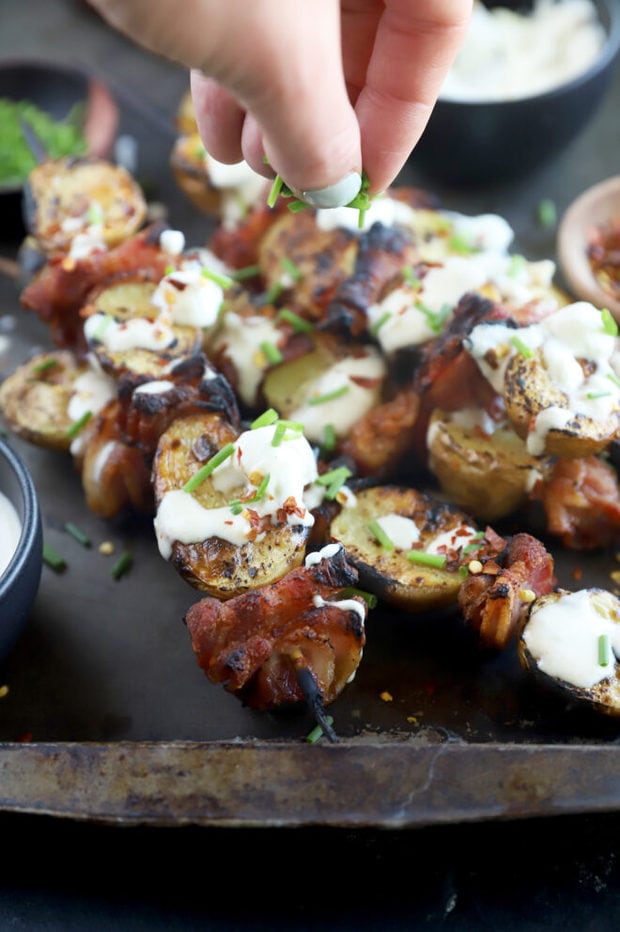 Sprinkling chives on top of skewers image