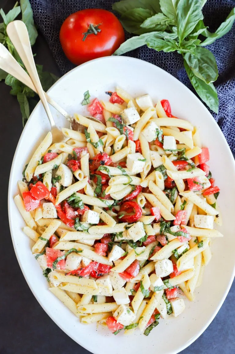 spoons in serving bowl for penne and vegetable side dish