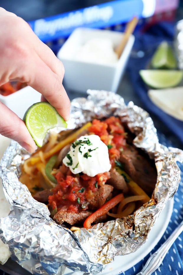 Squeezing a lime over steak fajitas image