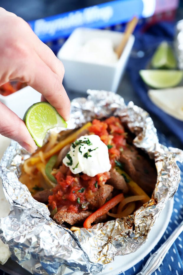 Squeezing a lime over steak fajitas image