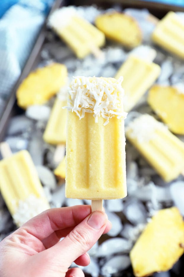 Hand holding pineapple coconut popsicle picture