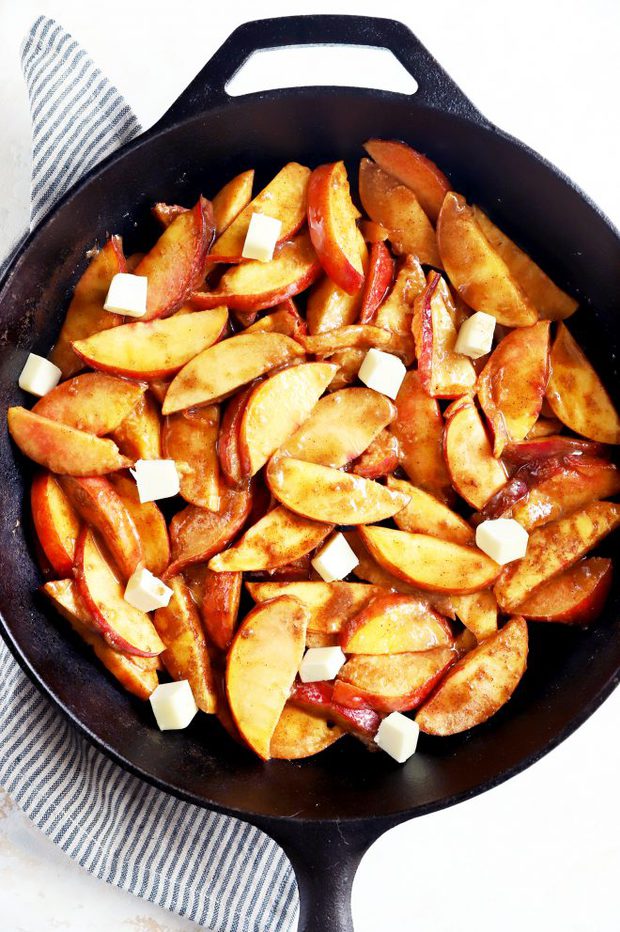 Fresh peaches with sugar and butter in a skillet image