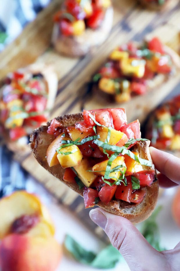 Image of hand holding tomato and peach appetizer photo