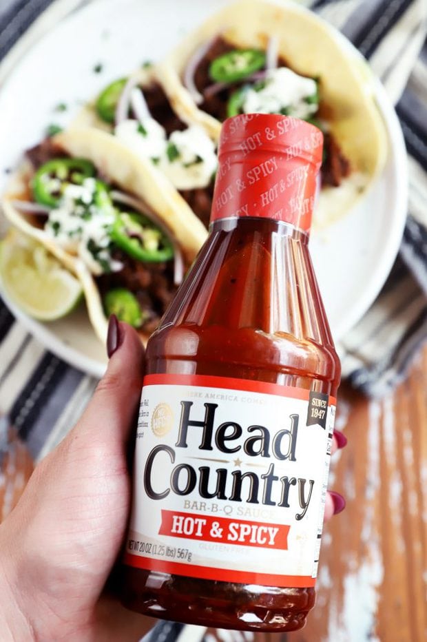 hand holding head country BBQ sauce picture