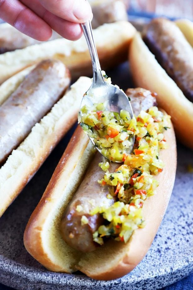 Putting relish on bratwurst image