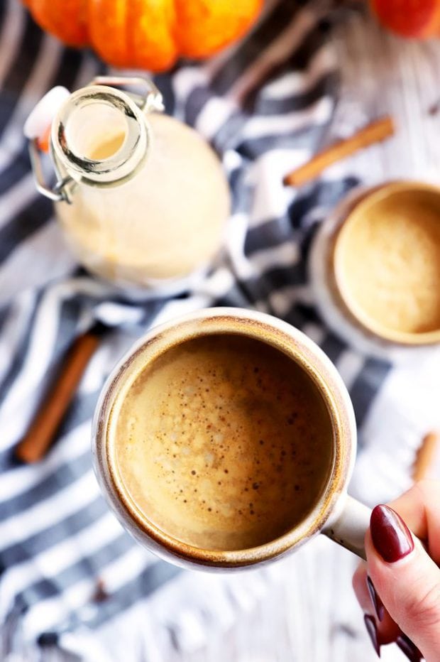 Hand holding mug of pumpkin coffee picture