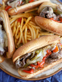 Philly cheesesteaks on plate with fries image