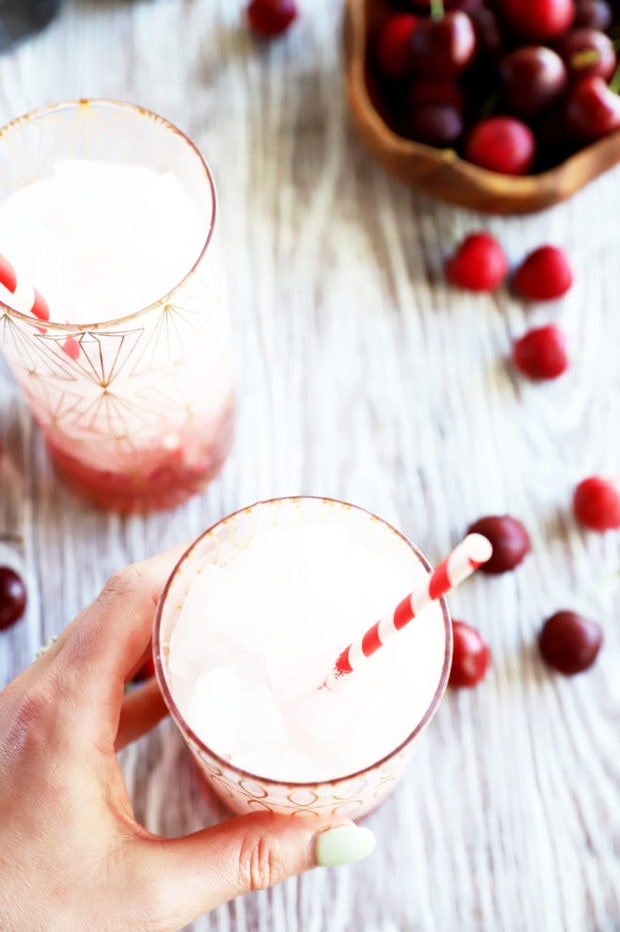 Hand holding cherry soda in glass