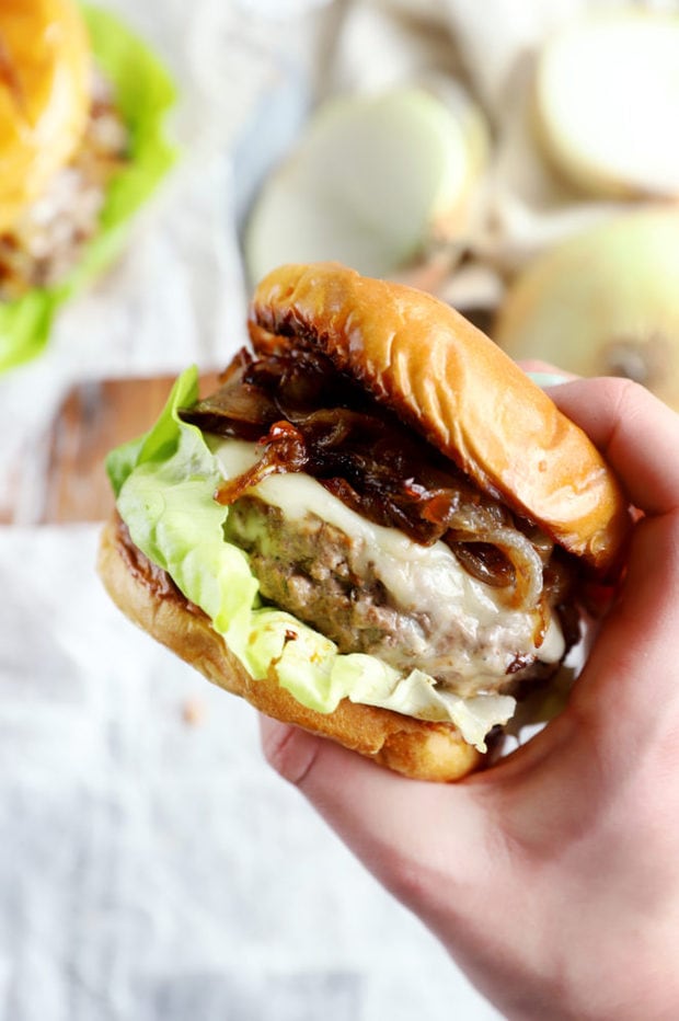 Hand holding french onion burger