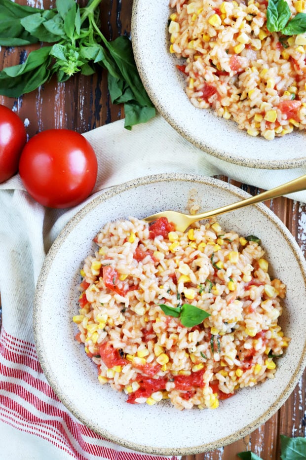 Photo of risotto in bowls with tomatoes and corn