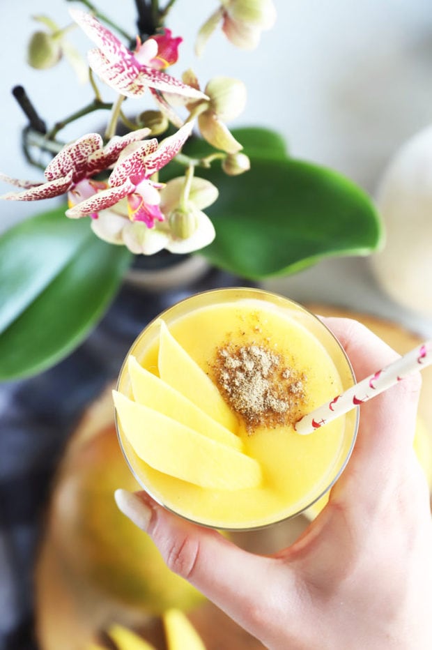 Hand holding glass of coconut lassi image