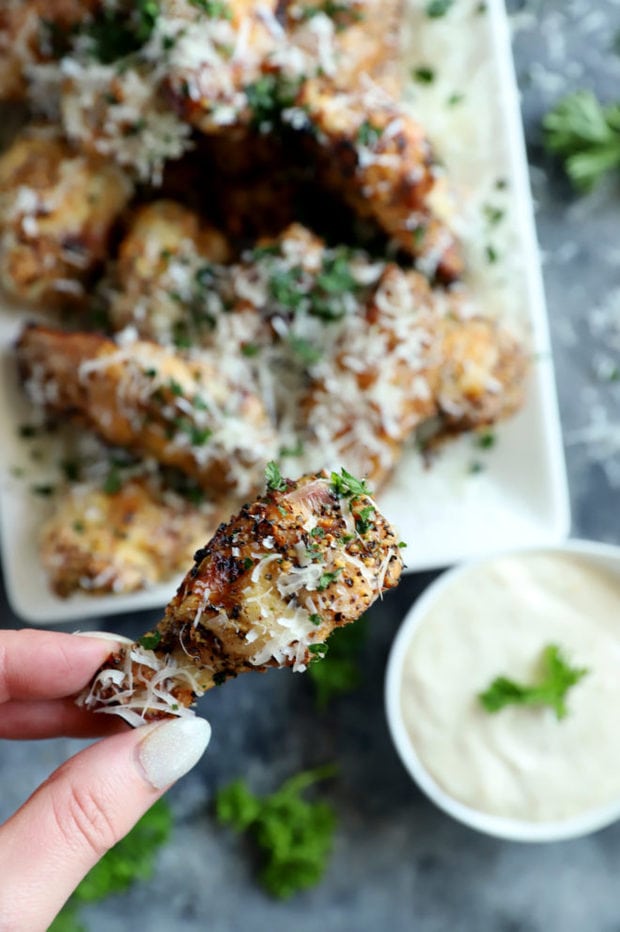 Hand holding a cacio e pepe chicken wing photo