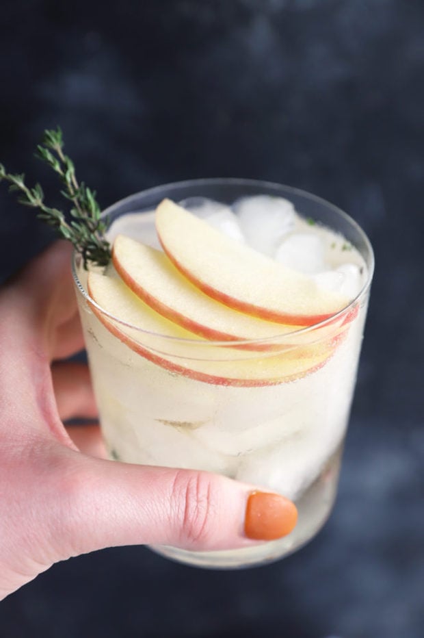 Hand holding apple gin and tonic image