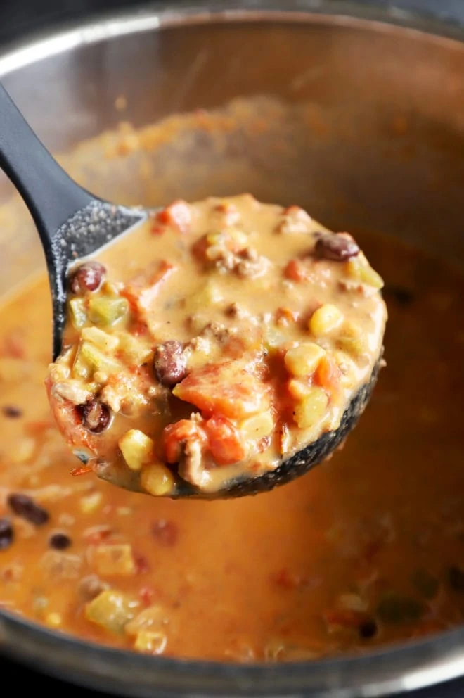 Ladle spooning out slow cooker queso chili photo