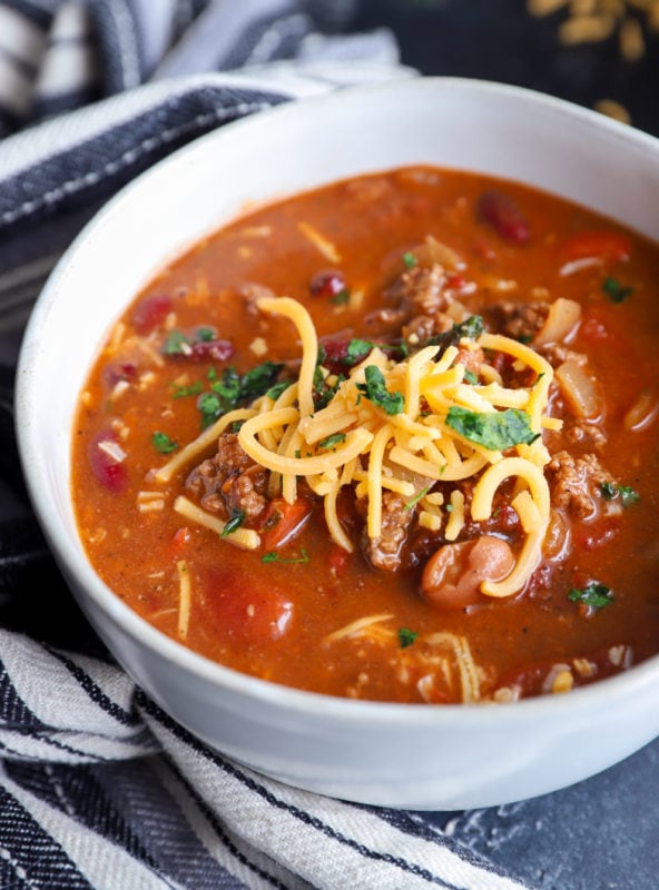 Shredded cheese on top of soup in a bowl image