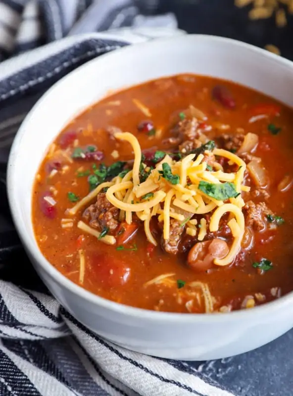 Shredded cheese on top of soup in a bowl image