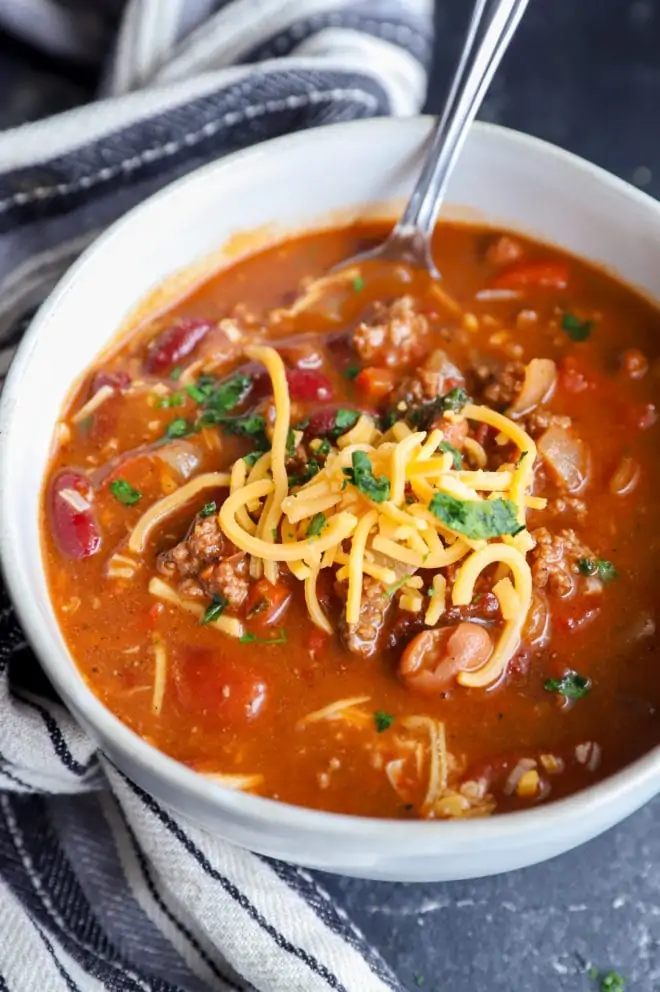 Spoon in a bowl of chipotle chili with cheese on top image