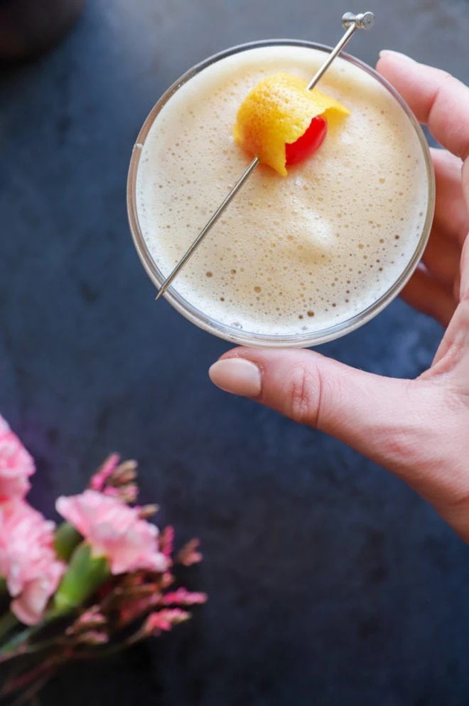 Hand holding cocktail in coupe glass