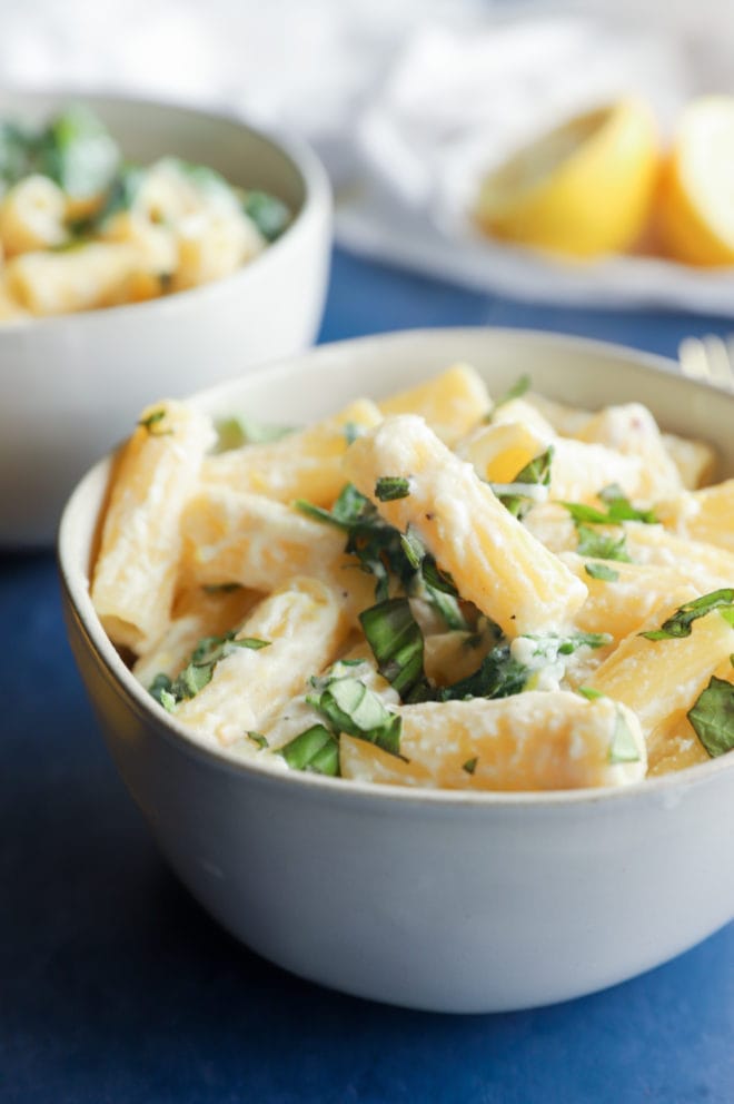 Photo of rigatoni in a bowl with ricotta and arugula