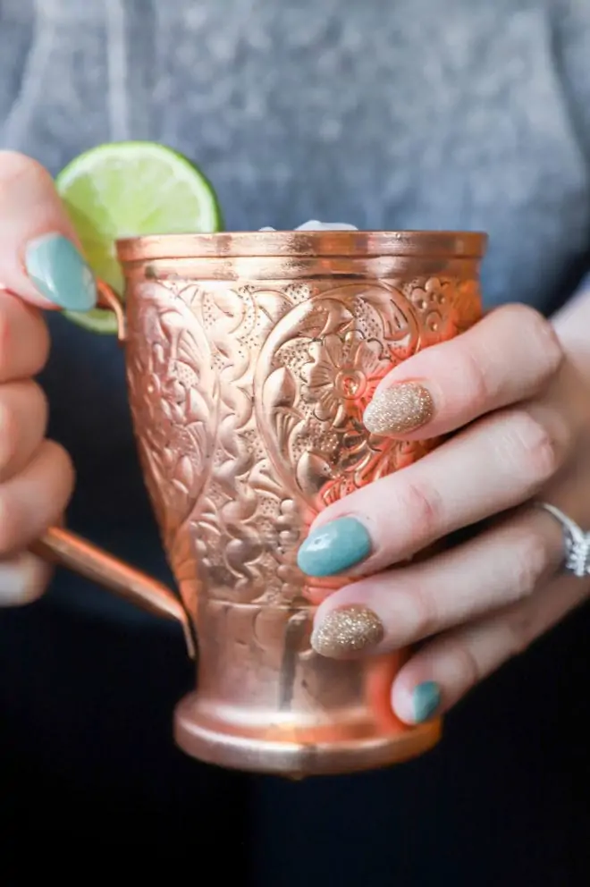 Side photo of hands holding copper mug